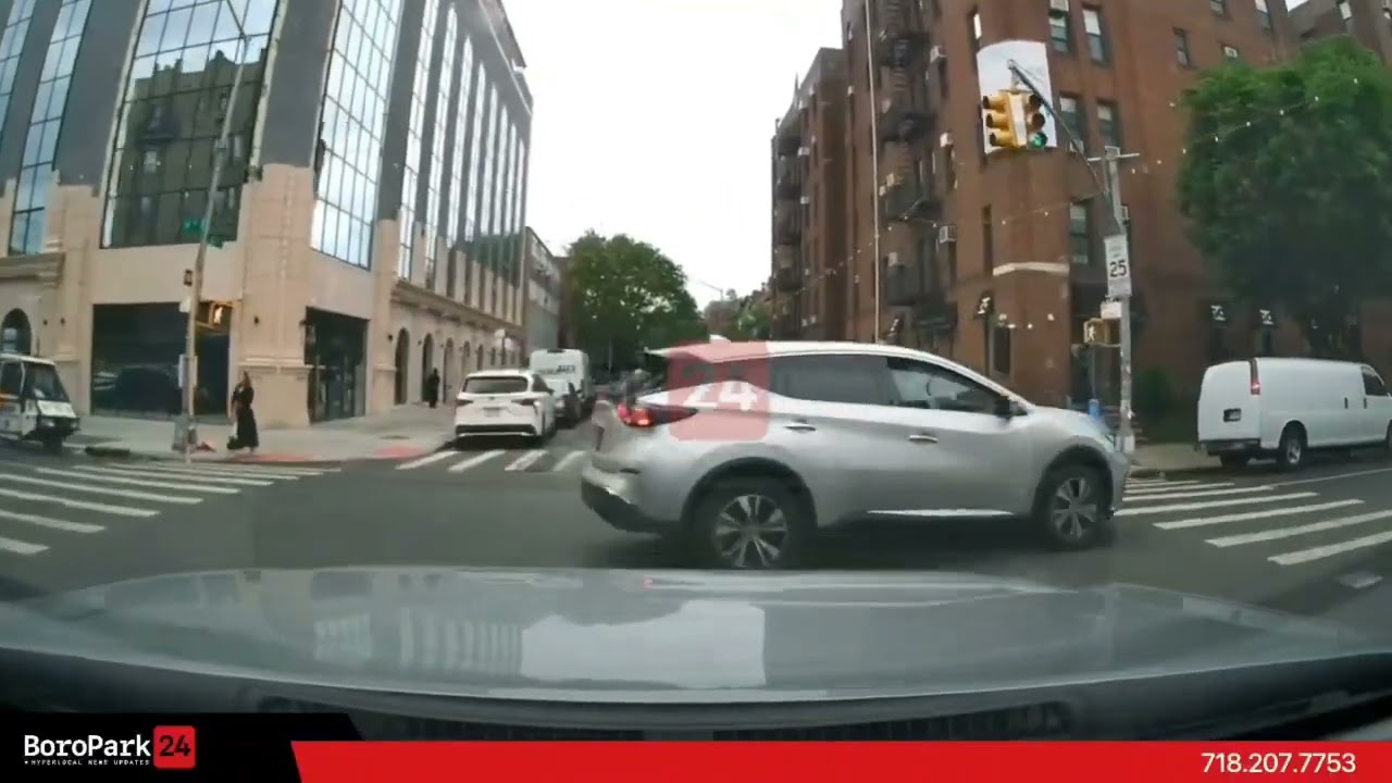 A car is seen speeding through a red light, nearly causing an accident