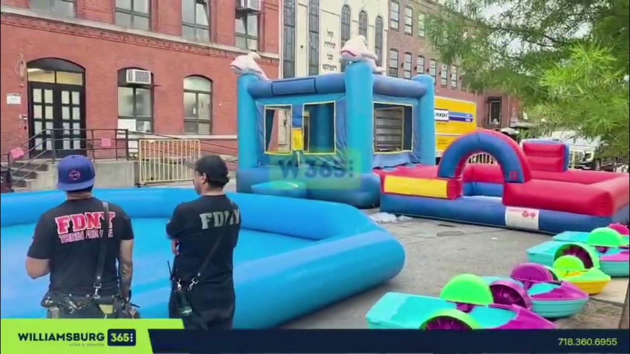 Firefighters filling the inflatable water rides with water by Satmar Cheider Day Camp