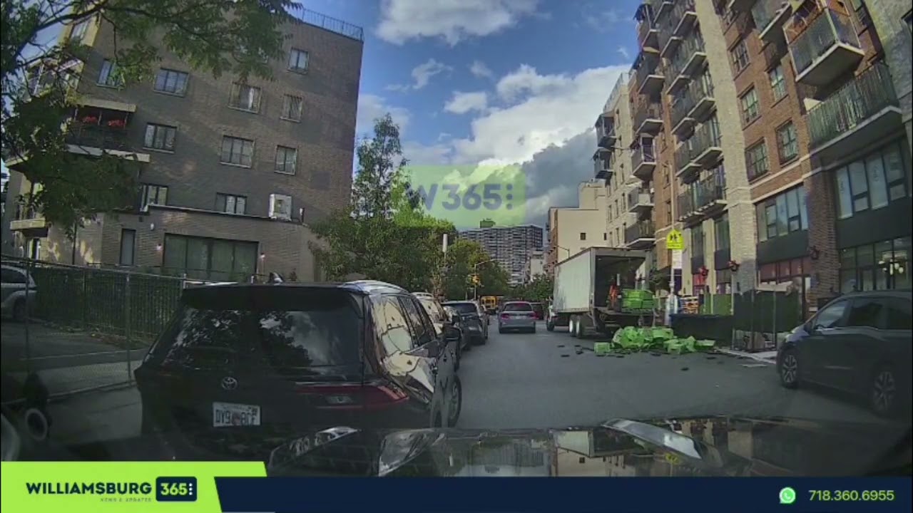 Pallet falls from delivery truck, sending boxes spilling onto the street.