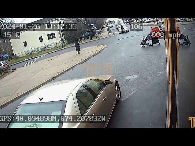 Vehicle passes school bus nearly striking mother and child