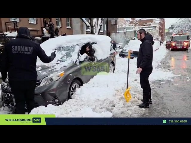 Shomrim volunteers are seen assisting a vehicle in moving away from a manhole fire.