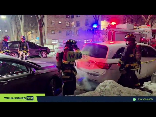 Firefighters on Ellery Street, where smoke is coming from a manhole with a vehicle parked on it.