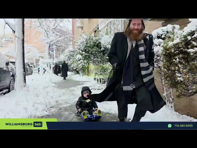 The snow brings a moment of fun, as a child is seen riding a sled through the winter streets.