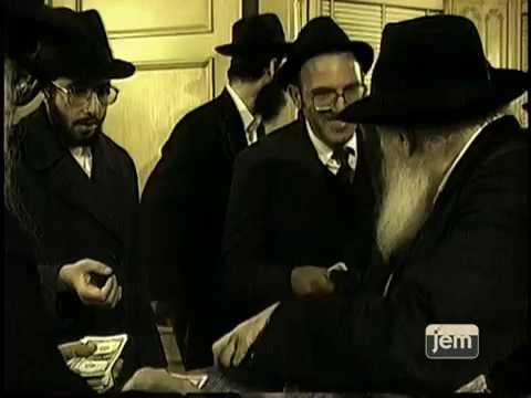 The Rebbe distributing dollars for charity in his home