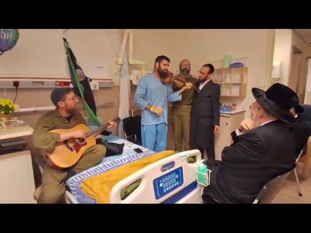האדמו"ר מקרלין שליט"א בביקור אצל חייל פצוע מאזין לניגון קה אכסוף להרה"ק רבי אהרן הגדול מקרלין זצוק"ל
